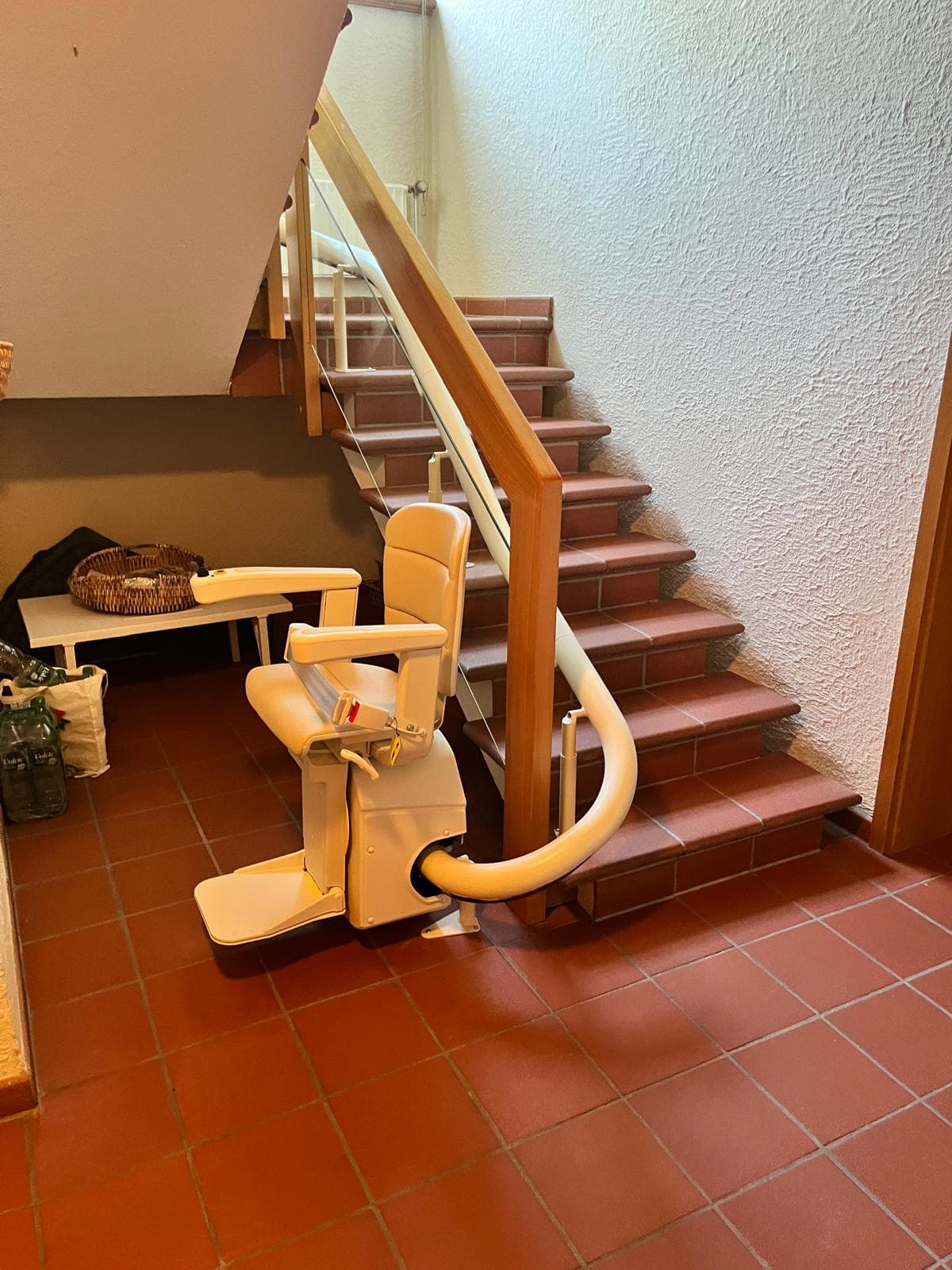 Kurven-Sitzlift an einer Innentreppe mit Holzgeländer